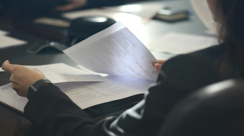 A person reading a document at a table