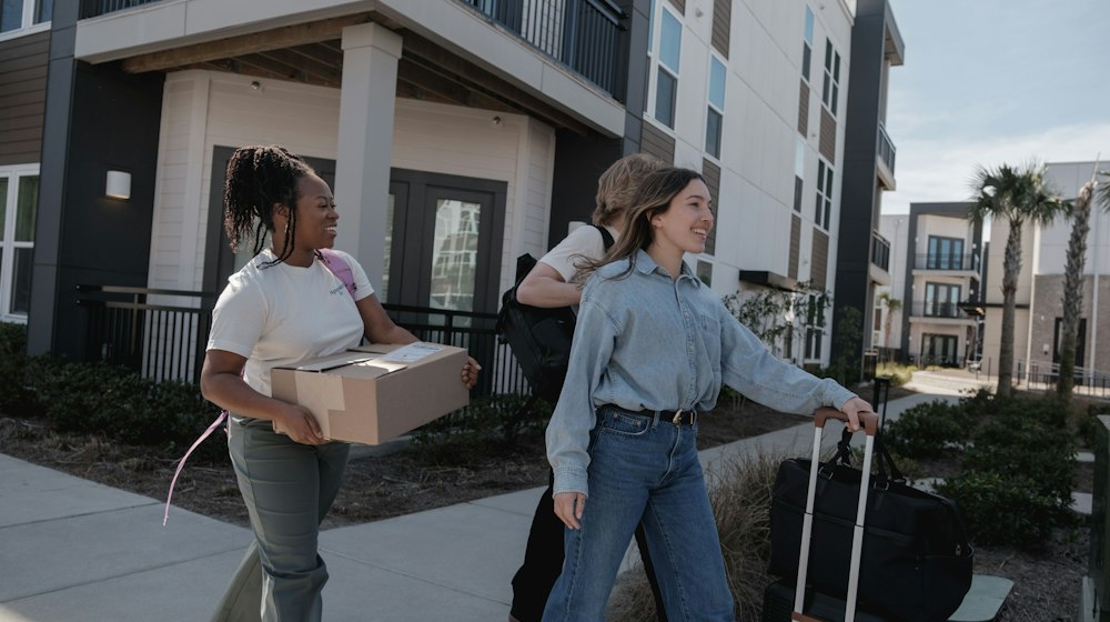 People carrying boxes and belongings outside